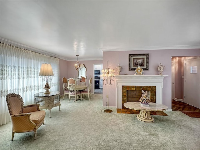 living area featuring carpet, baseboards, a chandelier, ornamental molding, and a fireplace