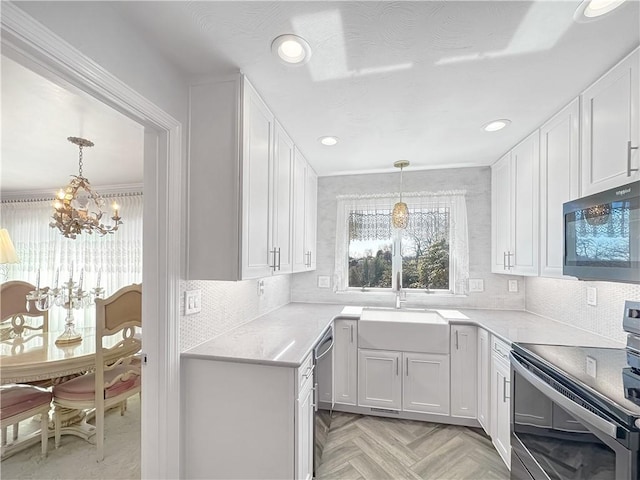 kitchen with a notable chandelier, white cabinetry, and stainless steel appliances