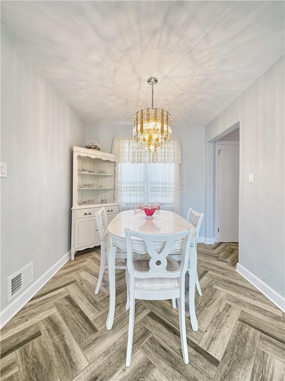 dining room with visible vents, baseboards, and a chandelier