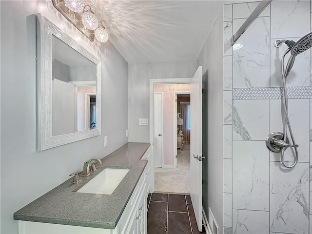 bathroom with a marble finish shower and vanity