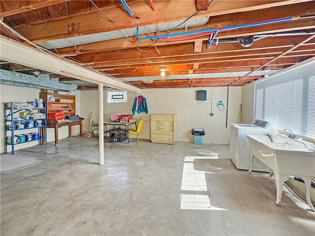 basement with washing machine and clothes dryer and concrete block wall