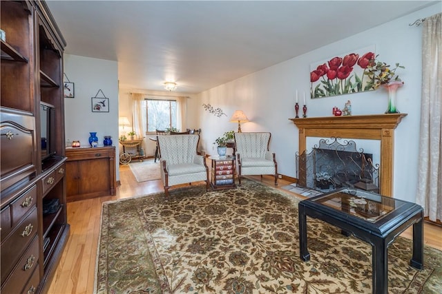 living area with light wood finished floors and a fireplace with flush hearth