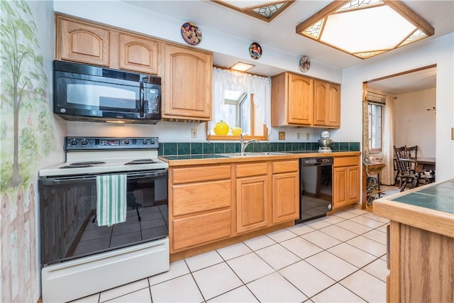 kitchen featuring a sink, black appliances, tile counters, and light tile patterned floors