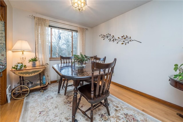 dining space with baseboards and light wood-style floors