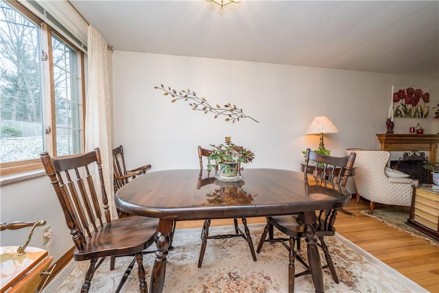 dining area with a fireplace and light wood-style floors