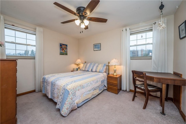 bedroom with light colored carpet, baseboards, and ceiling fan