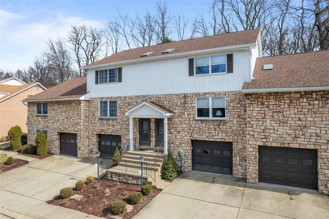 view of front of property with driveway, a shingled roof, and a garage