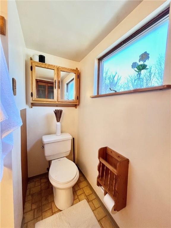 bathroom with toilet and stone tile flooring