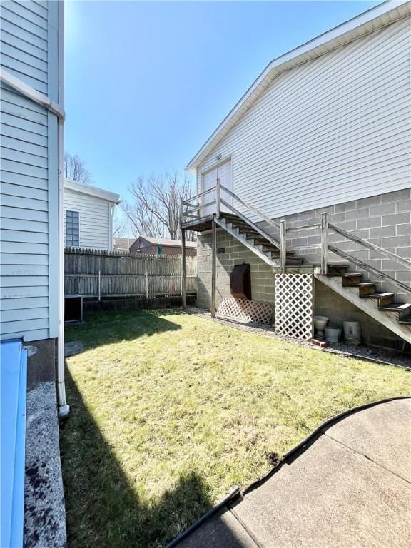 view of yard with stairs and fence