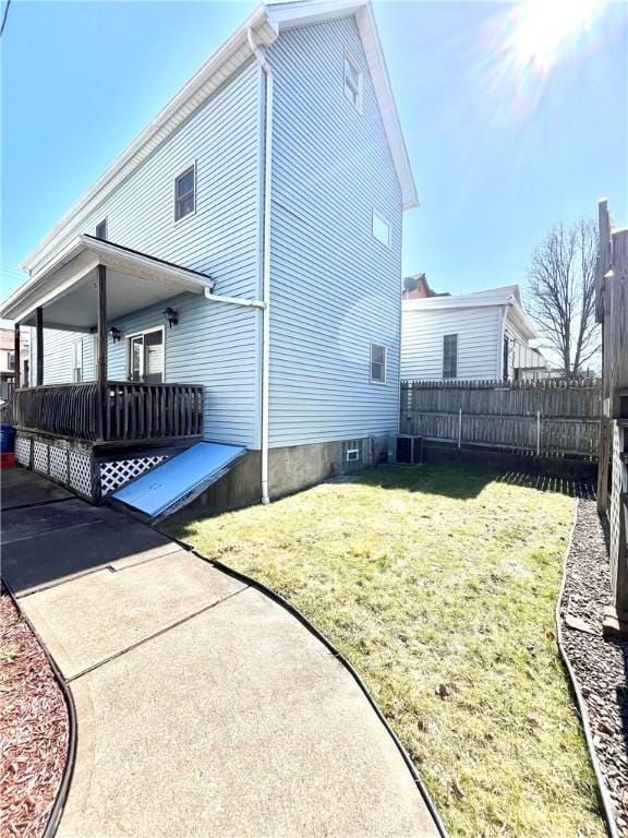 view of home's exterior with a yard and fence