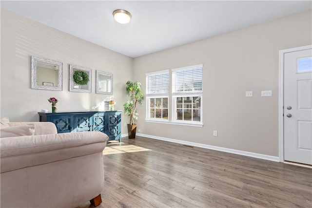 living area with visible vents, baseboards, and wood finished floors