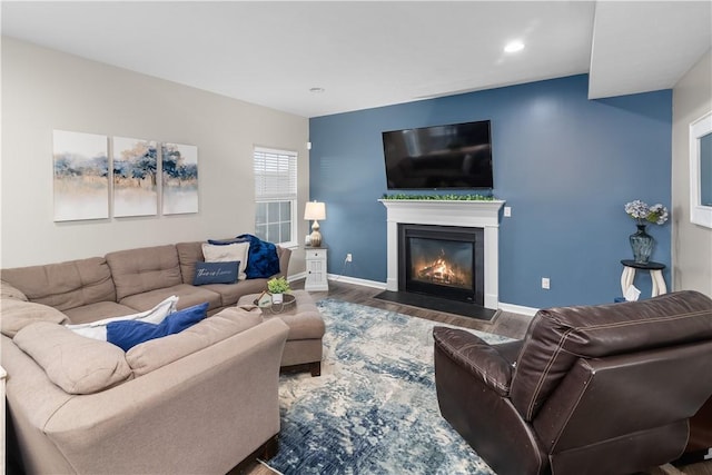 living area with recessed lighting, baseboards, a fireplace with flush hearth, and wood finished floors