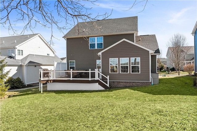 back of house with a wooden deck, a yard, and a shingled roof