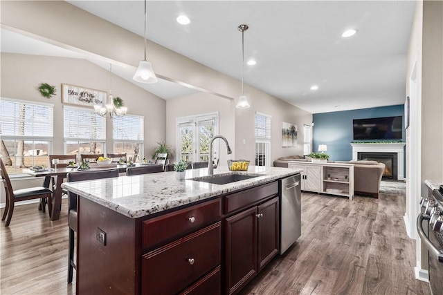 kitchen featuring range, dishwasher, wood finished floors, and a sink