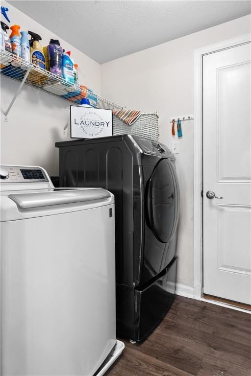 clothes washing area with baseboards, dark wood-type flooring, separate washer and dryer, and laundry area