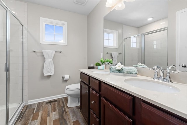 bathroom with a shower stall, wood finished floors, and a sink