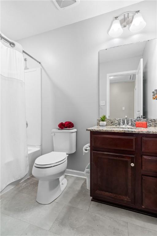 bathroom with visible vents, toilet, shower / bath combination with curtain, baseboards, and vanity