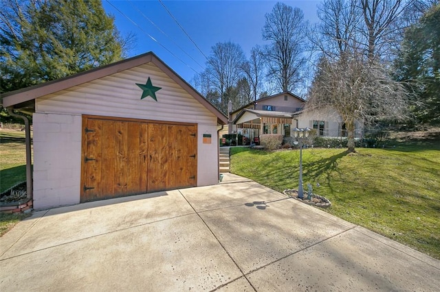 exterior space featuring a front lawn, an outbuilding, and a garage