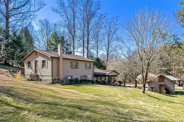 view of property exterior with cooling unit, a lawn, and a chimney