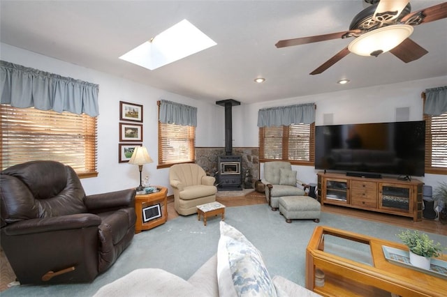 living area with a wood stove, plenty of natural light, recessed lighting, and carpet floors