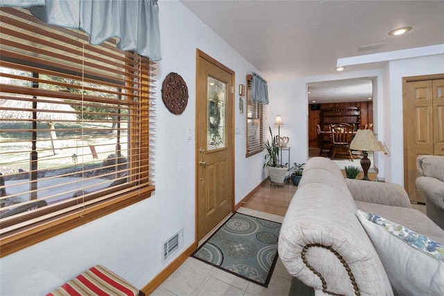 entrance foyer with light tile patterned floors, baseboards, and visible vents