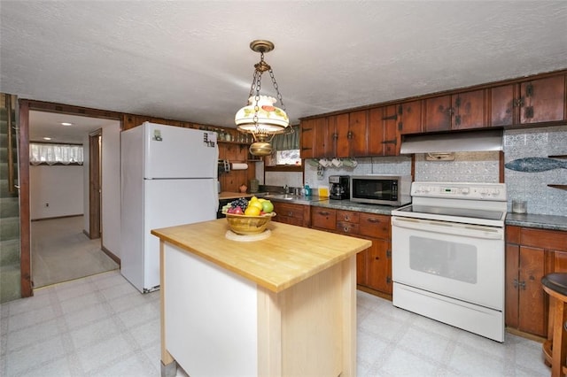 kitchen featuring white appliances, light floors, butcher block countertops, under cabinet range hood, and a textured ceiling