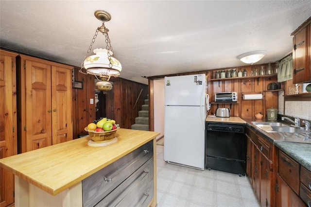 kitchen with light floors, dishwasher, butcher block counters, freestanding refrigerator, and a sink