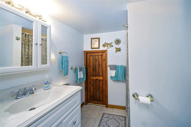 full bath featuring vanity, tile patterned floors, and baseboards