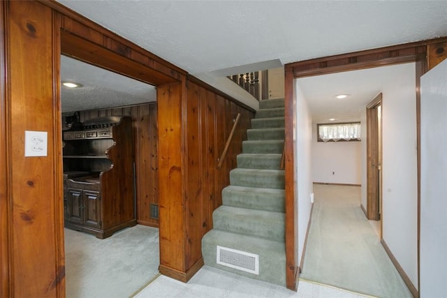 staircase featuring visible vents and carpet flooring