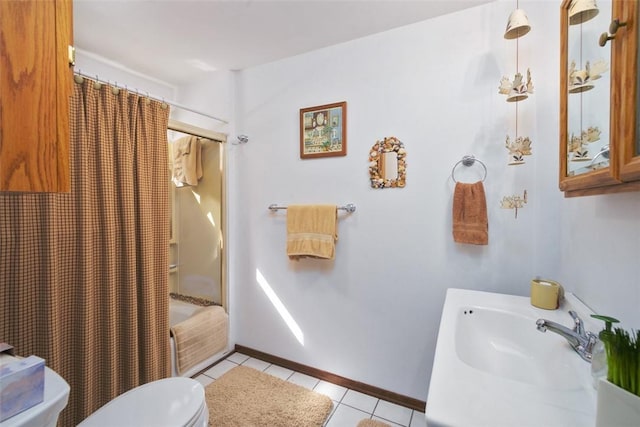 full bath featuring baseboards, shower / bath combo, a sink, tile patterned floors, and toilet