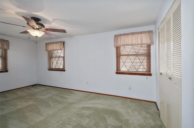 empty room featuring a ceiling fan, baseboards, and carpet floors