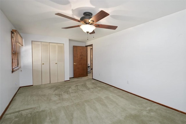 unfurnished bedroom with a closet, baseboards, carpet, and ceiling fan