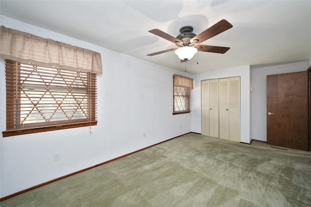 unfurnished bedroom with a closet, carpet floors, baseboards, and a ceiling fan