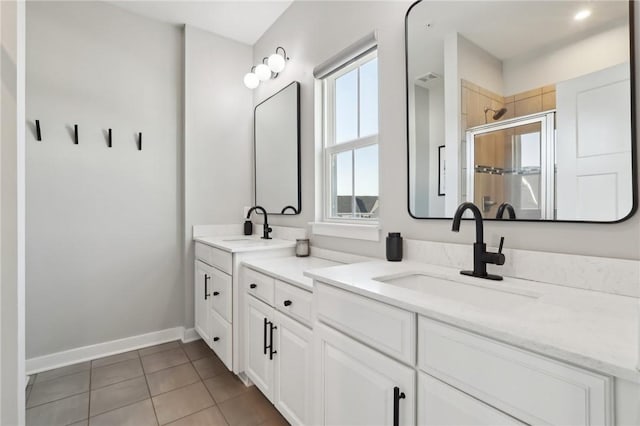 bathroom featuring a sink, double vanity, a stall shower, and tile patterned floors