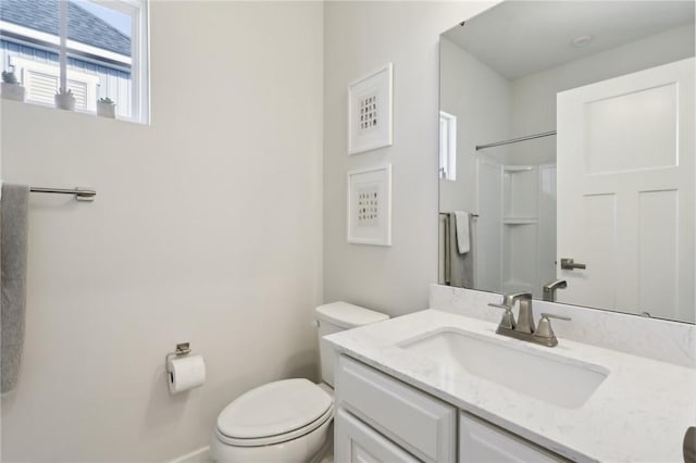 bathroom with a shower, baseboards, toilet, and vanity