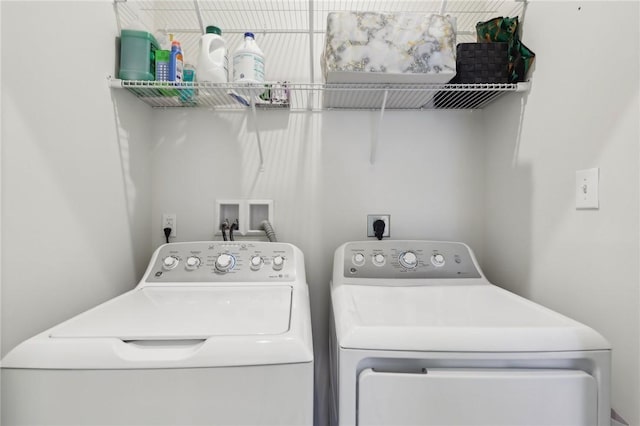 clothes washing area with washing machine and clothes dryer and laundry area