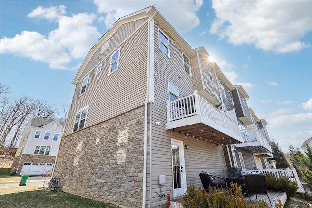 view of property exterior with stone siding and a wooden deck