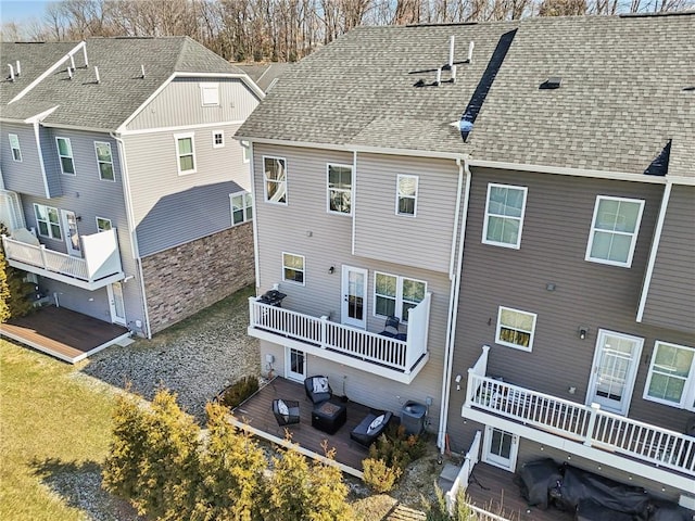 exterior space featuring a wooden deck and a shingled roof