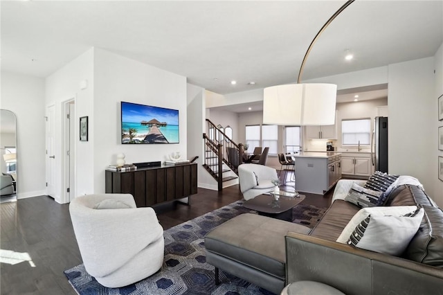 living area featuring stairs, recessed lighting, arched walkways, baseboards, and dark wood-style flooring