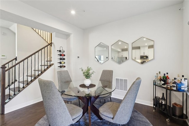 dining space with stairway, wood finished floors, visible vents, baseboards, and recessed lighting