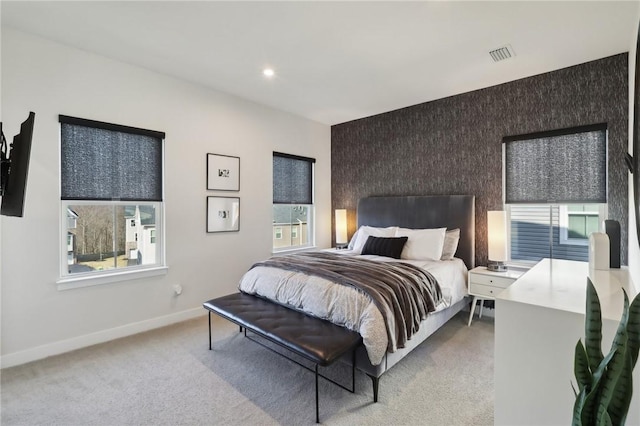 bedroom featuring visible vents, recessed lighting, baseboards, light colored carpet, and an accent wall