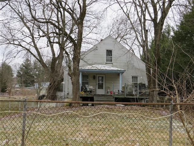 rear view of house with a fenced front yard and covered porch