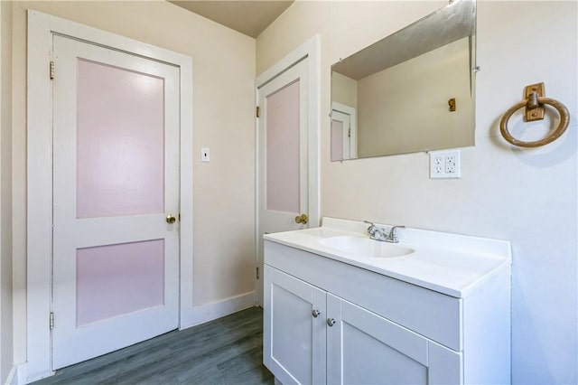 bathroom with vanity, wood finished floors, and baseboards