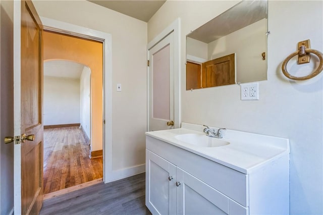 bathroom featuring vanity, baseboards, and wood finished floors