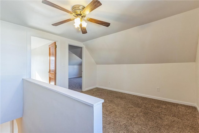 additional living space with vaulted ceiling, carpet flooring, baseboards, and ceiling fan