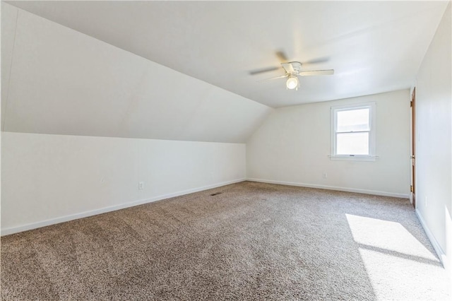 additional living space with lofted ceiling, carpet flooring, a ceiling fan, and baseboards