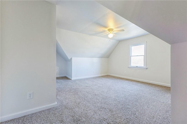 additional living space with vaulted ceiling, carpet, baseboards, and ceiling fan