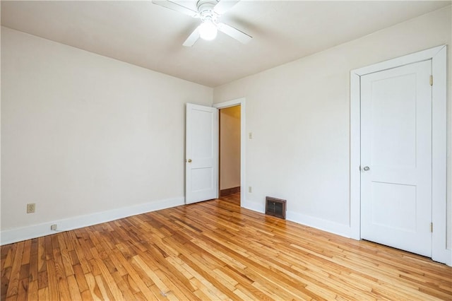 spare room with baseboards, visible vents, a ceiling fan, and light wood-style floors