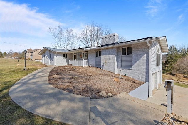 ranch-style home with driveway, a porch, an attached garage, a front lawn, and brick siding