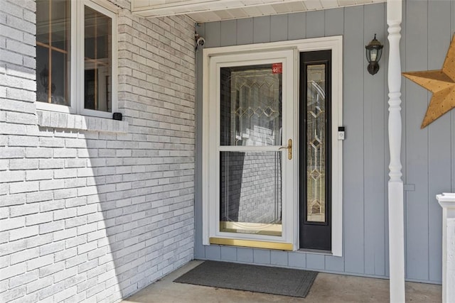 doorway to property featuring brick siding